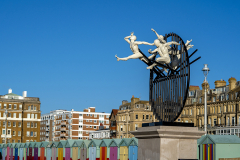 Flight of the Langoustine, by Pierre Diamantopoulo MRSS. It is made of four life-size bronze figures flying through a steel grid. It was inspired by a discarded and mangled lobster pot that the artist had found on Brighton beach. In his imagination, the washed-up object that had seemingly helped the lobsters escape, translated itself into a wider story of human exodus and release – a dash for freedom. Diamantopoulo describes the figures as “at once profound, frivolous and boisterous, occupying the air like a flock of birds and inspired by modern dance choreography”. Bronze casting at Milwyn Foundry and fabrication of the steel grid and assembly by Art Fabrications. The sculpture weighs 2.2 tonnes and measures approximately 3.5 metres high and 3 meters wide. Flight of the Langoustine was inaugurated on the Hove Plinth on 17 September 2023. Flight of the Langoustine, by Pierre Diamantopoulo MRSS. It is made of four life-size bronze figures flying through a steel grid. It was inspired by a discarded and mangled lobster pot that the artist had found on Brighton beach. In his imagination, the washed-up object that had seemingly helped the lobsters escape, translated itself into a wider story of human exodus and release – a dash for freedom. Diamantopoulo describes the figures as “at once profound, frivolous and boisterous, occupying the air like a flock of birds and inspired by modern dance choreography”. Bronze casting at Milwyn Foundry and fabrication of the steel grid and assembly by Art Fabrications. The sculpture weighs 2.2 tonnes and measures approximately 3.5 metres high and 3 meters wide. Flight of the Langoustine was inaugurated on the Hove Plinth on 17 September 2023.