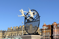 Flight of the Langoustine, by Pierre Diamantopoulo MRSS. It is made of four life-size bronze figures flying through a steel grid. It was inspired by a discarded and mangled lobster pot that the artist had found on Brighton beach. In his imagination, the washed-up object that had seemingly helped the lobsters escape, translated itself into a wider story of human exodus and release – a dash for freedom. Diamantopoulo describes the figures as “at once profound, frivolous and boisterous, occupying the air like a flock of birds and inspired by modern dance choreography”. Bronze casting at Milwyn Foundry and fabrication of the steel grid and assembly by Art Fabrications. The sculpture weighs 2.2 tonnes and measures approximately 3.5 metres high and 3 meters wide. Flight of the Langoustine was inaugurated on the Hove Plinth on 17 September 2023. Flight of the Langoustine, by Pierre Diamantopoulo MRSS. It is made of four life-size bronze figures flying through a steel grid. It was inspired by a discarded and mangled lobster pot that the artist had found on Brighton beach. In his imagination, the washed-up object that had seemingly helped the lobsters escape, translated itself into a wider story of human exodus and release – a dash for freedom. Diamantopoulo describes the figures as “at once profound, frivolous and boisterous, occupying the air like a flock of birds and inspired by modern dance choreography”. Bronze casting at Milwyn Foundry and fabrication of the steel grid and assembly by Art Fabrications. The sculpture weighs 2.2 tonnes and measures approximately 3.5 metres high and 3 meters wide. Flight of the Langoustine was inaugurated on the Hove Plinth on 17 September 2023.